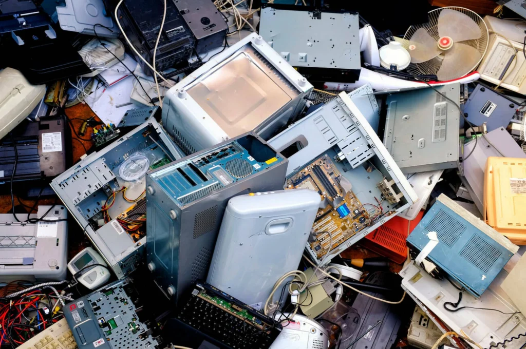 Residuos electrónicos como computadoras, cables y ventiladores acumulados en un tiradero